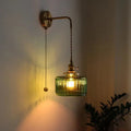 Wall Sconce with Green Glass Shade and Brass Arm in Light - Image 1